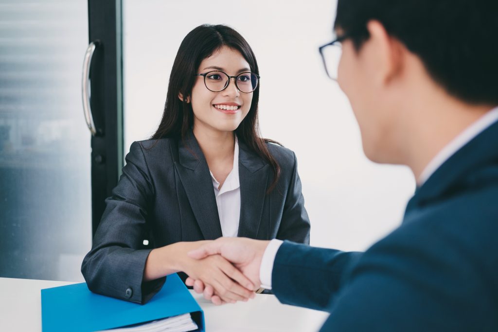 Two people shaking hands, smiling